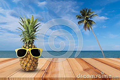 Pineapple on wooden table in a tropical landscape, Fashion hipster pineapple, Bright summer color, Tropical fruit with sunglasses Stock Photo