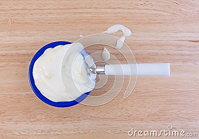 Pineapple yogurt on a wood table with spoon and spill Stock Photo