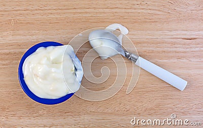 Pineapple yogurt on a wood table with spoon and spill Stock Photo