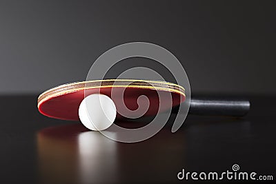 Ping pong racket and ball on dark table Stock Photo