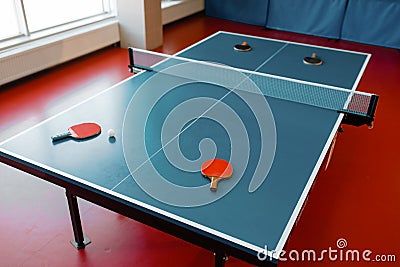 Ping pong rackets on game table with net, nobody Stock Photo