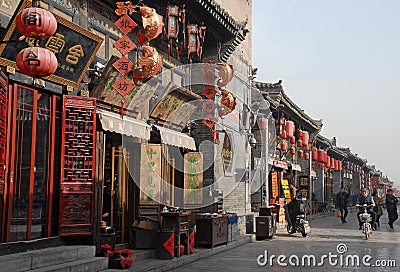 Pingyao in Shanxi Province, China: A main street in Pingyao with a hotel, shops and stores Editorial Stock Photo