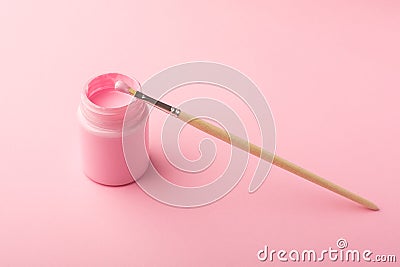 Pink acrylic paint with a brush on pink background, simple pastel composition Stock Photo