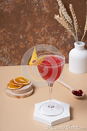 Pink alcoholic cocktail in steamed glasse on white podium or pedestal Stock Photo