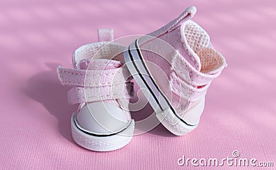 Pink baby shoes on a gentle pink background. The concept of the first steps, birthday, expectation, pregnancy, motherhood, Stock Photo