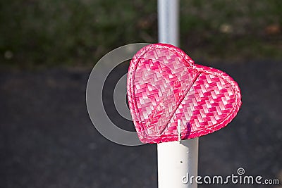 Pink bamboo wood heart over blurred background, morning outdoor day light Stock Photo