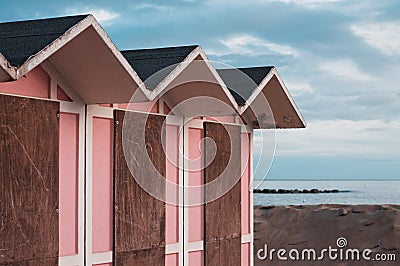 Pink beach cabins in the bathhouse on the sand with Mediterranean sea in background Italy, Europe Stock Photo