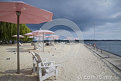The pink beach umbrellas and Adirondack chairs at the downtown public park Editorial Stock Photo