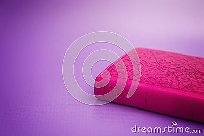 Pink Bible on a Purple Background Stock Photo