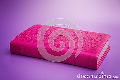 Pink Bible on a Purple Background Stock Photo