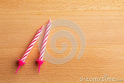 2 pink birthday candles on wooden background. For birthday greeting card. Space to insert text. Stock Photo