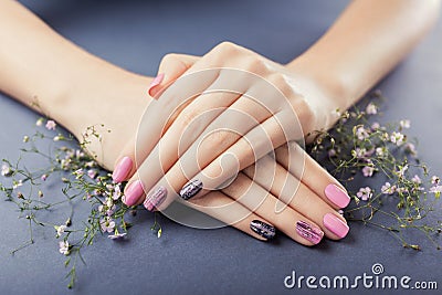 Pink and black manicure with flowers on grey background. Nail art Stock Photo