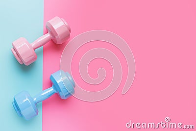 Pink and blue dumbbells on pastel background with copy space for text. Training with weights, fitness, sports and health concept. Stock Photo