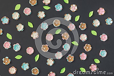 Pink and blue flowers are randomly laid out on a black background. Artificial paper flowers. Stock Photo