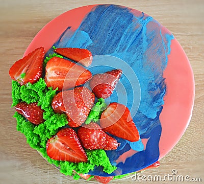 Pink and blue mirror glaze mousse cake with berries and sponge bisquit. Homemade strawberries cake Stock Photo