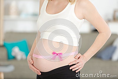 pink bow around mothers baby bump Stock Photo