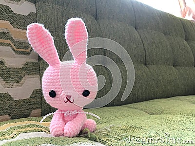 Pink bunny crochet doll in soft focus. Stock Photo