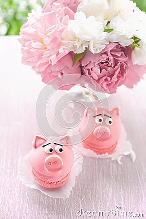 Pink cakes in the shape of pigs with a bouquet of peonies on the holiday. Copy the place. Stock Photo