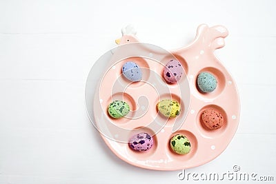 Pink ceramic chiken with colorful eggs on soft blurred background. Easter concept Stock Photo