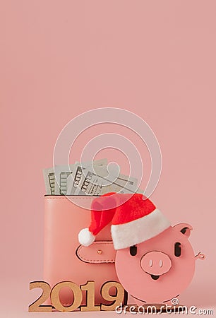 Pink Christmas pig and purse with dollars and inscription 2019 on a pink background Stock Photo