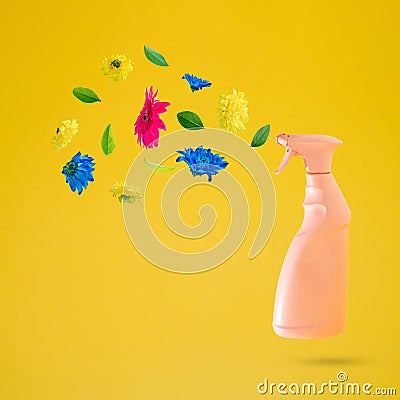 Pink cleaning spray bottle with flowers flying on a yellow background. Positive news, thinking and energy concept. Optimistic Stock Photo