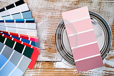 Pink coloured swatch for tinting on paint can standing on wooden background Stock Photo