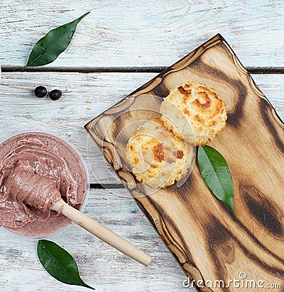 Pink cream honey with a spoon spindle on a table, near cookies on a board, top view Stock Photo