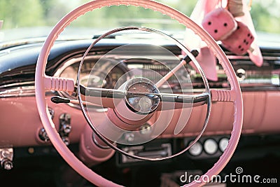 The pink dashboard and steering wheel of a classic car Stock Photo