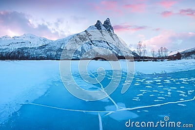 Pink early morning glow light on snow covered mountains in arctic norway, super wide panoramic scene. Scenic winter view Stock Photo