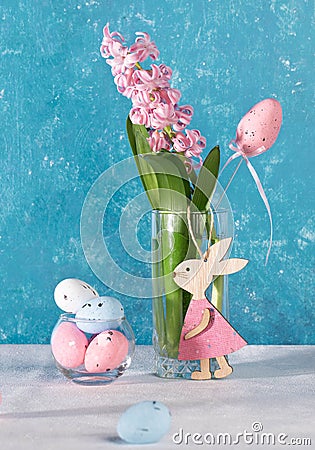 Pink Easter decorations decorative eggs, cute wooden bunny, jacinth flower in glass. Vertical format Stock Photo