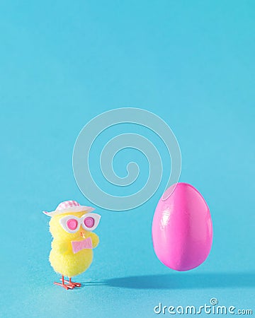 Pink Easter egg flying. Modern yellow chicken with sun glasses and hat. Spring summer sunny concept idea Stock Photo