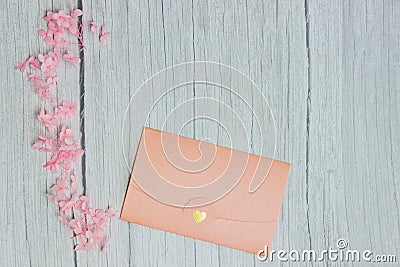 Pink envelop with pink flowers over the wooden background. Stock Photo