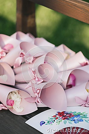 Pink envelopes, paper bags of rose petals and a Chinese fan Stock Photo