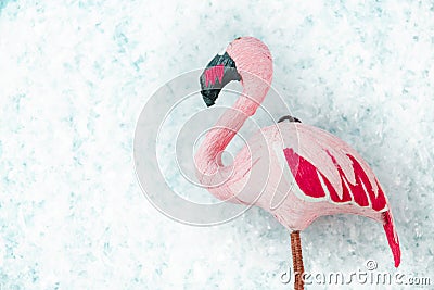 Pink flamingo on turquoise background with snow, selective focus top view Stock Photo