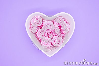 Pink flowers in a heart-shaped casket against a lilic background. Valentines day background. Mother`s Day, March 8th Stock Photo