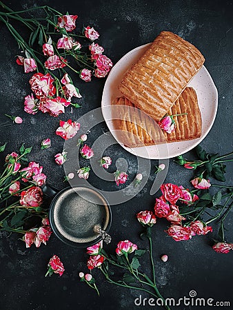 Pink flowers, puff pastries and coffee on a dark background, Bush roses, Blog style, Flatlay, Floral, Postcard Stock Photo