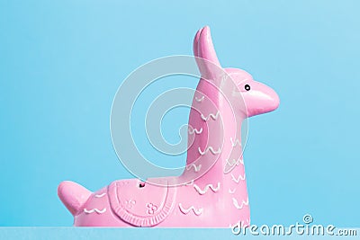 Pink funny toy lama head on blue background Stock Photo