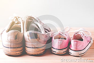 Pink girl sneakers and White man sneakers on a wooden floor Stock Photo