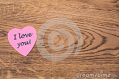 Pink heart post-it with the text `I love you` on a wooden background Stock Photo