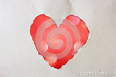 Pink heart shape made from torn paper over glitter boke soft lights. Stock Photo