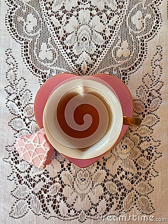 Pink heart shaped teacup with heart shaped frosted cake Stock Photo