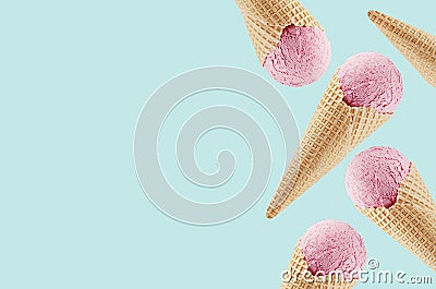 Pink ice cream in crisp waffle cones as decorative border on pastel green background, mock up, copy space. Stock Photo