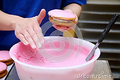 pink icing being applied by hand Stock Photo