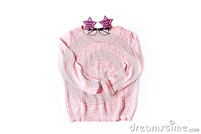 Pink knitted sweater with festive New Year glasses on white background, top view Stock Photo