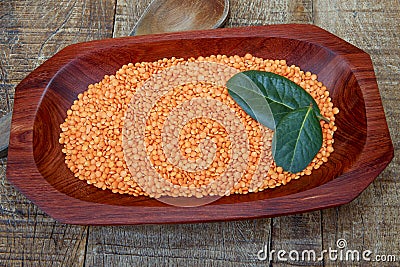 Pink lentil on wooden platter over rustic wooden table Stock Photo