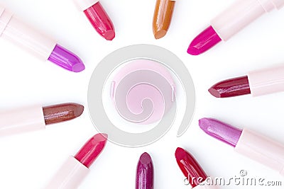 Pink makeup puff and various colors lipsticks Stock Photo