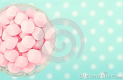 Pink marshmallows on polkadot blue blurred background Stock Photo