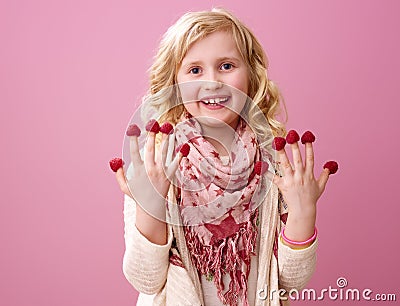 Happy child isolated on pink with raspberries on fingers Stock Photo