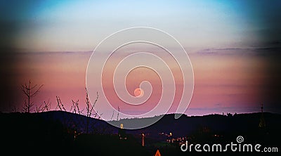 Pink moon against sunset and clouds in Germany Stock Photo