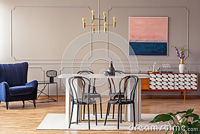 Pink and navy blue abstract painting on a gray wall with molding in an elegant dining and living room Stock Photo